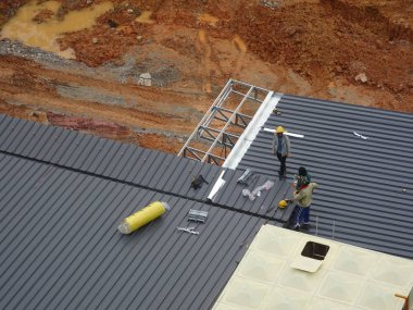 Kuala Lumpur, Malezya - 4 Temmuz 2018: İnşaat işçileri tarafından metal güverte çatı levha montajı. İle çatı yalıtımı ve ısı yansıtıcı sayfasını tamamlayın.