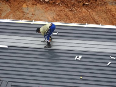 Kuala Lumpur, Malezya - 4 Temmuz 2018: İnşaat işçileri tarafından metal güverte çatı levha montajı. İle çatı yalıtımı ve ısı yansıtıcı sayfasını tamamlayın.