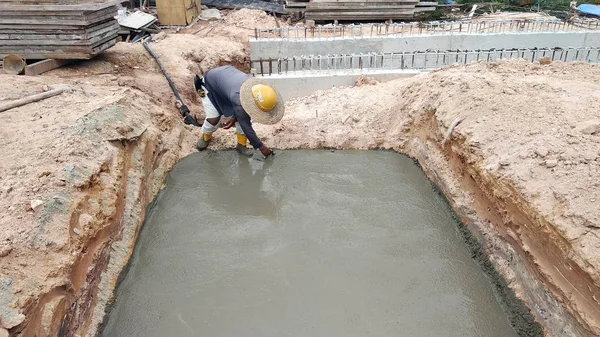 Kuala Lumpur, Malezya-05 Temmuz 2018: inşaat işçileri el float ıslak beton dökülerek tesviye. Çimento mala kullanarak elle yapılan. 