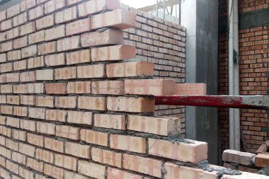 Kuala Lumpur, Malezya-28 Mart 2018: tuğla inşaat sahasında inşaat işçileri tarafından. Çimento tuğla lay ve birlikte harç formu duvara kullanarak yığılmış. Bu iş için gerekli gerekli araçlar. 