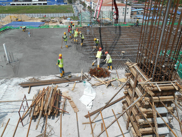 KUALA LUMPUR, MALAYSIA -AUGUST 27, 2018: Concreting work by construction workers at the construction site. Heavy machinery used to carry wet concrete to the pouring location. 