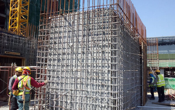 KUALA LUMPUR, MALAYSIA-MARCH 29 14, 2016: Строители изготавливают стальные арматурные прутки для формирования арматурного бетона на строительной площадке
. 