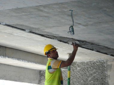 Kuala Lumpur, Malezya-23 Ağustos 2018: çimento alçı kullanarak inşaat işçileri tarafından sıvalı tuğla duvar. İskele geçici evreleme olarak yükseklikte çalışırdım. Kötü olmasını önlemek için uygun güvenlik dişli giyiyor.  