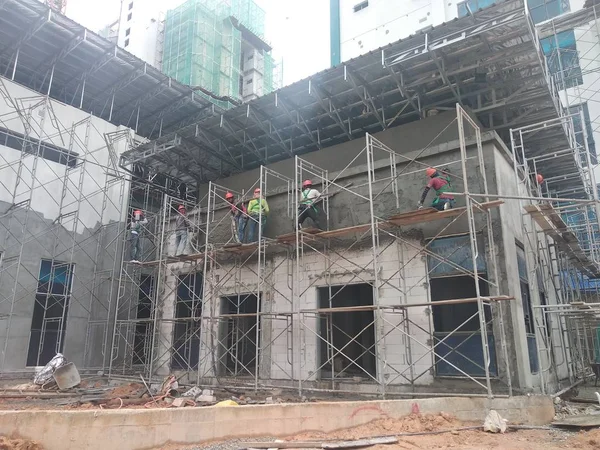 马来西亚吉隆坡 2018年8月23日 建筑工人用水泥石膏贴上砖墙 脚手架用作临时分期工作在高度 穿戴适当的安全装备防止坏发生 — 图库照片