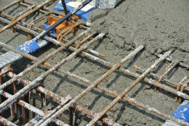 Selangor, Malezya-26 Temmuz 2016: ıslak beton betonarme döşeme güçlendirmek denilen güçlü zemin plakaları oluşturmak için bir çelik takviye çubuğunda dökülür. 