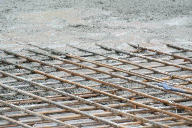 Selangor, Malezya-26 Temmuz 2016: ıslak beton betonarme döşeme güçlendirmek denilen güçlü zemin plakaları oluşturmak için bir çelik takviye çubuğunda dökülür. 