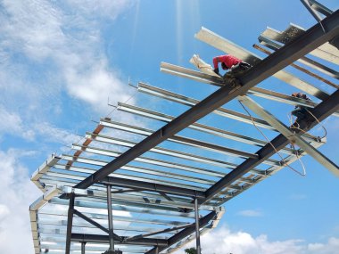 Kuala Lumpur, Malezya-14 Ağustos 2018: inşaat işçileri metal çatı makasları inşaat sahasında yükleme. Metal Çatı makas metal çatı tam yükleme işleminden sonra almak olacaktır.  