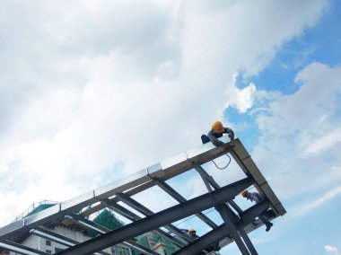 Kuala Lumpur, Malezya-14 Ağustos 2018: inşaat işçileri metal çatı makasları inşaat sahasında yükleme. Metal Çatı makas metal çatı tam yükleme işleminden sonra almak olacaktır.  