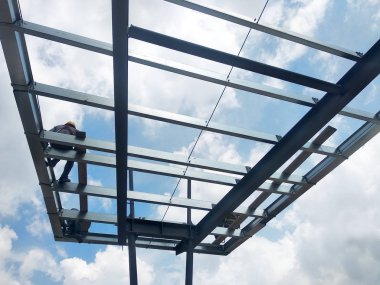 Kuala Lumpur, Malezya-14 Ağustos 2018: inşaat işçileri metal çatı makasları inşaat sahasında yükleme. Metal Çatı makas metal çatı tam yükleme işleminden sonra almak olacaktır.  