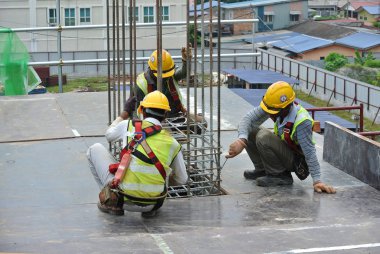 KUALA LUMPUR, MALAYSIA -JUNE 27, 2016: Construction workers fabricating steel reinforcement bar at the construction site in. The reinforcement bar was ties together using tiny wire.