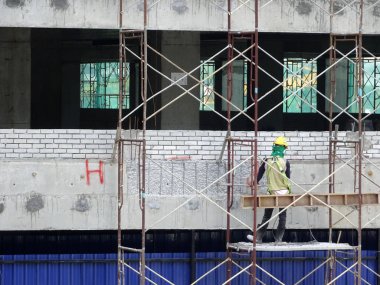 Kuala Lumpur, Malezya-25 Temmuz 2017: Metal inşaat sahasında inşaat işçileri tarafından yüklenen iskele. Üzerinde çalışmak için geçici destek yapısı ve işçiler için platform olarak kullanılır.  