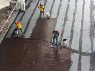 Kuala Lumpur, Malezya-25 Haziran 2017: Betonarme döşeme üzerine inşaat işçileri tarafından uygulanan membran su yalıtımı. Su betonarme döşeme altına girmesini önlemek için su yalıtım katmanı. 