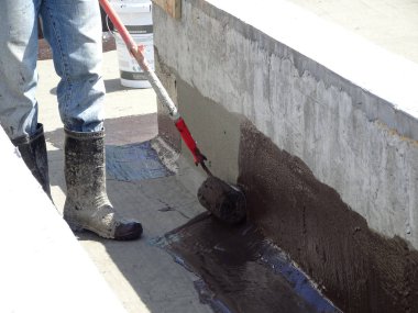 Kuala Lumpur, Malezya-25 Haziran 2017: Betonarme döşeme üzerine inşaat işçileri tarafından uygulanan membran su yalıtımı. Su betonarme döşeme altına girmesini önlemek için su yalıtım katmanı. 