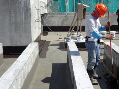 Kuala Lumpur, Malezya-25 Haziran 2017: Betonarme döşeme üzerine inşaat işçileri tarafından uygulanan membran su yalıtımı. Su betonarme döşeme altına girmesini önlemek için su yalıtım katmanı. 