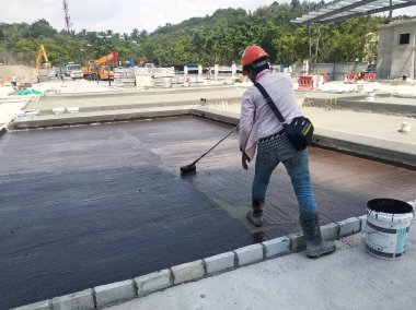 Kuala Lumpur, Malezya-25 Temmuz 2018: Betonarme döşeme üzerine inşaat işçileri tarafından uygulanan membran su yalıtımı. Su betonarme döşeme altına girmesini önlemek için su yalıtım katmanı. 