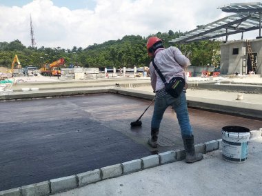 Kuala Lumpur, Malezya-25 Temmuz 2018: Betonarme döşeme üzerine inşaat işçileri tarafından uygulanan membran su yalıtımı. Su betonarme döşeme altına girmesini önlemek için su yalıtım katmanı. 