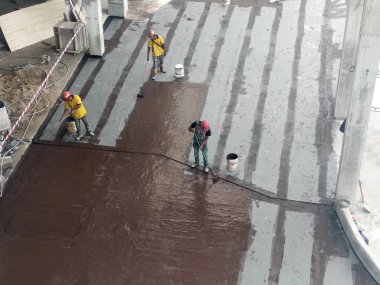 Kuala Lumpur, Malezya-25 Temmuz 2018: Betonarme döşeme üzerine inşaat işçileri tarafından uygulanan membran su yalıtımı. Su betonarme döşeme altına girmesini önlemek için su yalıtım katmanı. 