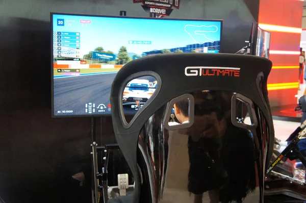 KUALA LUMPUR, MALAYSIA -NOVEMBER 23, 2017: People playing with race car simulation game. Displayed with big screen monitors complete with cockpit controls like a real racing car.