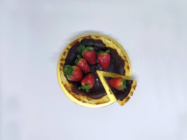 Bask Cheesecake üst altı çilek ile yanmış. Beyaz arka plan üzerinde izole.  