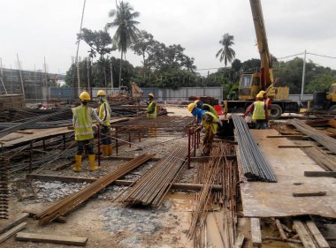 Kuala Lumpur, Malezya-16 Temmuz 2018: bar bükme çelik takviye çalışan inşaat işçileri bahçesinde inşaat alanında. Bir profil bükme Makinası kullanarak çelik bükme. 
