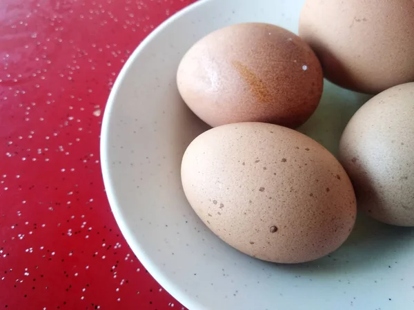 Empat Telur Rebus Ditempatkan Piring Putih Ditempatkan Atas Meja Merah — Stok Foto