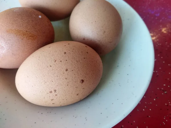 Empat Telur Rebus Ditempatkan Piring Putih Ditempatkan Atas Meja Merah — Stok Foto
