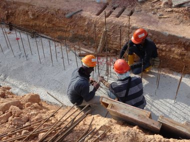 Kuala Lumpur, Malezya -Mart 29, 2010: İnşaat işçileri inşaat alanında takviye beton oluşturmak için çelik takviye çubuğu imal. Küçük kabloları kullanarak birbirine bağladılar.