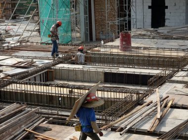 Kuala Lumpur, Malezya -Mart 29, 2010: İnşaat işçileri inşaat alanında takviye beton oluşturmak için çelik takviye çubuğu imal. Küçük kabloları kullanarak birbirine bağladılar.