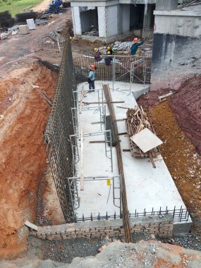 Kuala Lumpur, Malezya -Mart 29, 2010: İnşaat işçileri inşaat alanında takviye beton oluşturmak için çelik takviye çubuğu imal. Küçük kabloları kullanarak birbirine bağladılar.