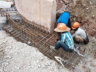 Kuala Lumpur, Malezya -Mart 29, 2010: İnşaat işçileri inşaat alanında takviye beton oluşturmak için çelik takviye çubuğu imal. Küçük kabloları kullanarak birbirine bağladılar.