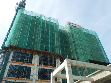 Kuala Lumpur, Malezya -16 Temmuz 2018: İnşaat sırasında yüksek katlı binanın dış iskelelerine güvenlik ağı kuruldu. Doğrudan toprağa düşen ve hasara neden olan yapı malzemelerinin israfını önlemektir..