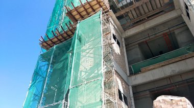 Kuala Lumpur, Malezya -16 Temmuz 2018: İnşaat sırasında yüksek katlı binanın dış iskelelerine güvenlik ağı kuruldu. Doğrudan toprağa düşen ve hasara neden olan yapı malzemelerinin israfını önlemektir..