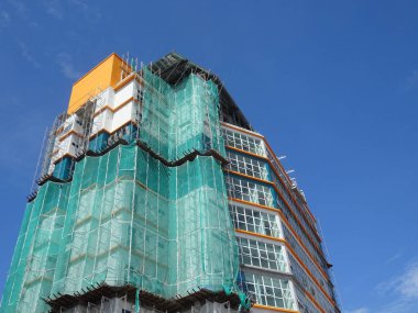 Kuala Lumpur, Malezya -16 Temmuz 2019: Yüksek katlı bina inşaatı sırasında binanın dış cephesinde platform ve güvenlik ağlarını yakalayın. Bireyleri ve malları düşen enkazlardan korur. 