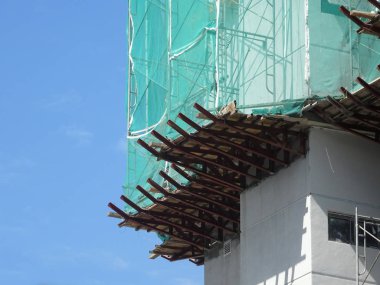 Kuala Lumpur, Malezya -16 Temmuz 2019: Yüksek katlı bina inşaatı sırasında binanın dış cephesinde platform ve güvenlik ağlarını yakalayın. Bireyleri ve malları düşen enkazlardan korur. 