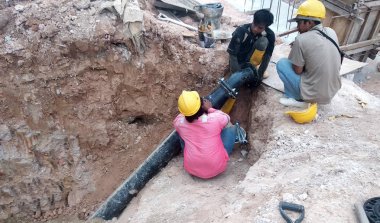 Kuala Lumpur, Malezya -12 Nisan 2019: Şantiyedeki siperlerde yeraltı hizmet borusunu tamir eden inşaat işçileri.     
