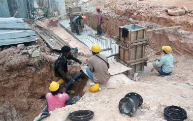 Kuala Lumpur, Malezya -12 Nisan 2019: Şantiyedeki siperlerde yeraltı hizmet borusunu tamir eden inşaat işçileri.     