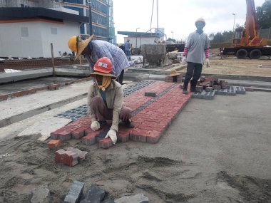 Kuala Lumpur, Malezya -15 Kasım 2017: Şantiye otoparkı alanında çalışanlar tarafından beton döşeme hazırlama ve montaj çalışmaları. Desen ve onaylı renk aşağıdaki düzenlenmiştir.  