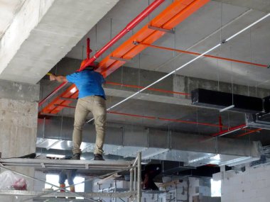 Kuala Lumpur, Malezya - 16 Eylül 2017: İnşaat işçileri zemine elektrik kablosu tepsisi taktılar. Kablo tepsisi tavan seviyesinin üzerine kurulur. 
