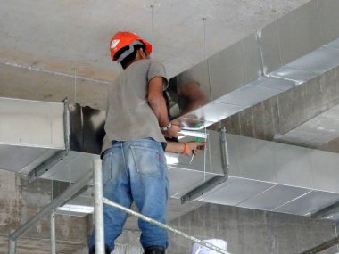 Kuala Lumpur, Malezya -16 Eylül 2017: İnşaat şantiyeye klima kanalı kuran inşaat işçileri. 