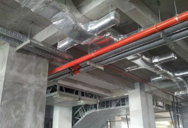 KUALA LUMPUR, MALAYSIA - SEPTEMBER 16, 2017: Air condition duct installed by construction workers  at the construction site  clipart