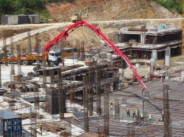 Kuala Lumpur, Malezya -25 Eylül 2017: İnşaat işçileri şantiyede fil vinç veya beton pompa vinç hortum kullanarak ıslak beton dökme.