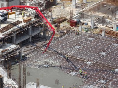 Kuala Lumpur, Malezya -25 Eylül 2017: İnşaat işçileri şantiyede fil vinç veya beton pompa vinç hortum kullanarak ıslak beton dökme.
