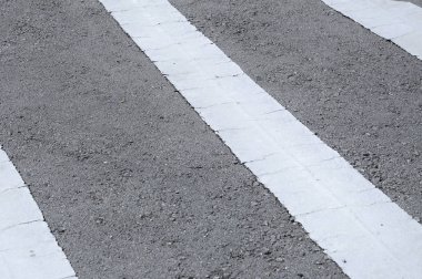 Beyaz termoplastik malzemeden yapılmış yol çizgisi işaretleme. 