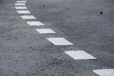 Beyaz termoplastik malzemeden yapılmış yol çizgisi işaretleme. 