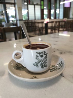 Beyaz çiçek desen fincan setleri kahve bir fincan masaya yerleştirilir