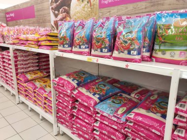 Kuala Lumpur, Malezya -2 Eylül 2018: Plastik ambalajdaki pirinç, satışa sunulan süpermarketin rafına yığılmış. Türü ve fiyatının çeşitliliği