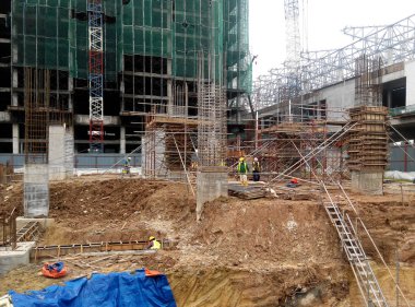 Kuala Lumpur, Malezya -30 Eylül 2016: İnşaat işçileri şantiyede çelik betonarme kolonu imal etti. Kereste ve metali kalıp olarak kullanıyorlar.. 