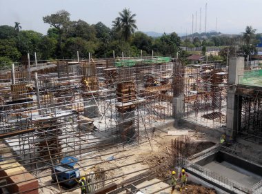 Kuala Lumpur, Malezya -30 Eylül 2016: İnşaat işçileri şantiyede çelik betonarme kolonu imal etti. Kereste ve metali kalıp olarak kullanıyorlar.. 