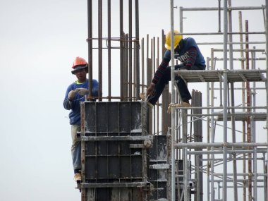 Kuala Lumpur, Malezya -30 Eylül 2016: İnşaat işçileri şantiyede çelik betonarme kolonu imal etti. Kereste ve metali kalıp olarak kullanıyorlar.. 
