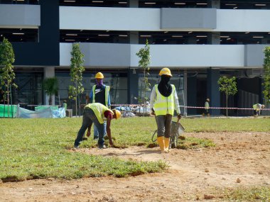 Kuala Lumpur, Malezya - 19 Mayıs 2017: Açık alanda inşaat işçileri tarafından çim çimleme çalışmaları. 